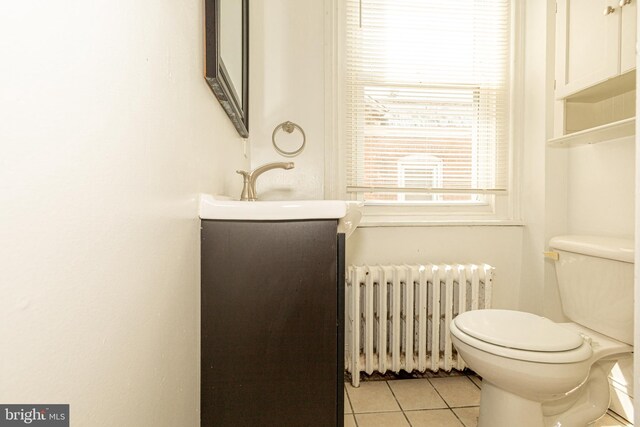 bathroom featuring vanity, toilet, radiator, and tile patterned floors