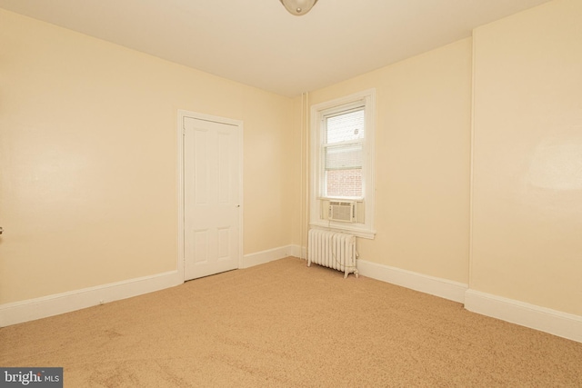 carpeted empty room with cooling unit and radiator heating unit