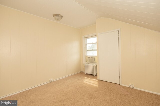 interior space featuring lofted ceiling, carpet, and radiator