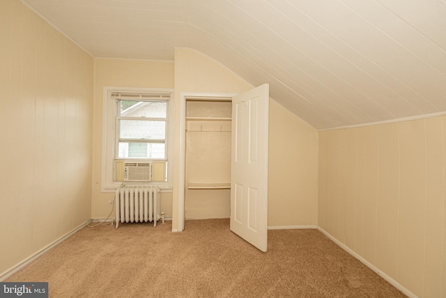 interior space featuring light carpet, radiator, vaulted ceiling, and cooling unit