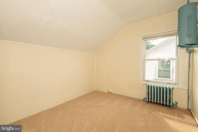 additional living space featuring lofted ceiling, radiator heating unit, and light carpet