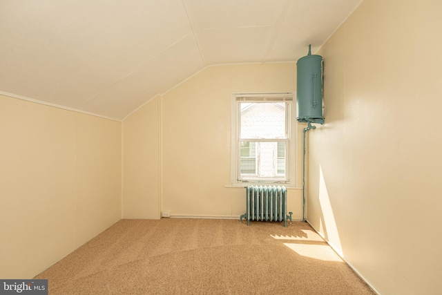 additional living space featuring carpet, water heater, radiator heating unit, and vaulted ceiling