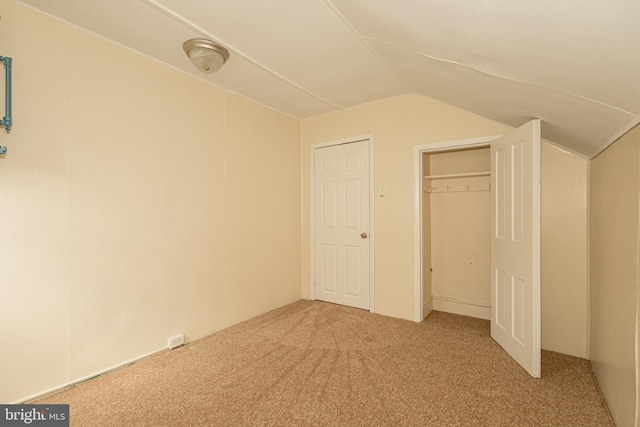 unfurnished bedroom with lofted ceiling and carpet flooring