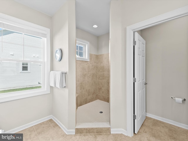 bathroom with tile patterned flooring and a tile shower