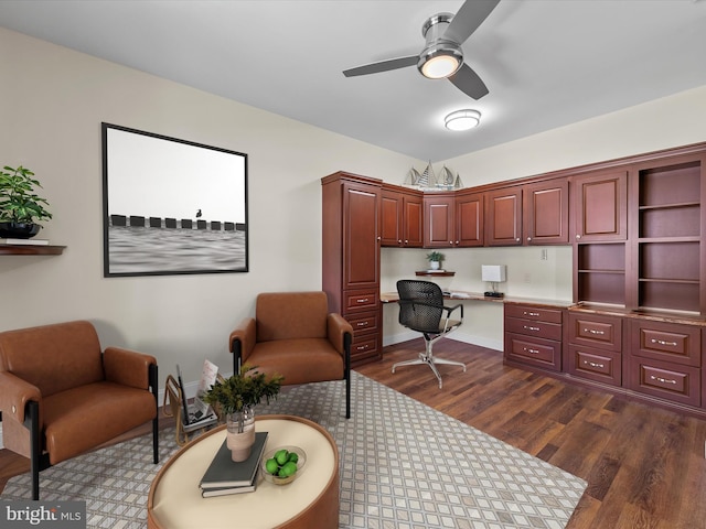 office area with dark hardwood / wood-style flooring, ceiling fan, and built in desk