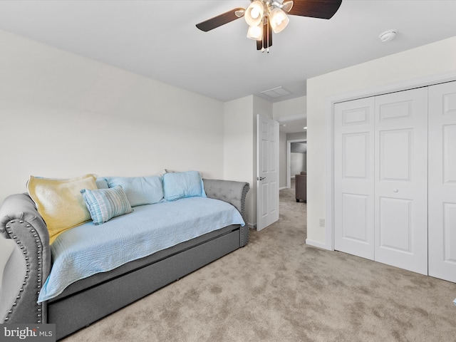 carpeted bedroom featuring ceiling fan and a closet