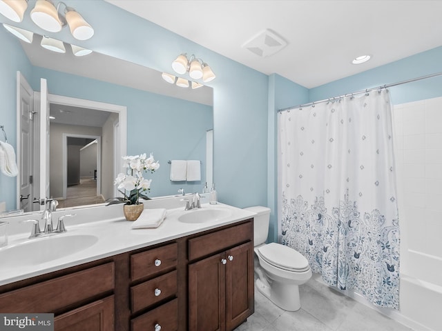 full bathroom featuring tile patterned flooring, vanity, toilet, and shower / bath combo with shower curtain