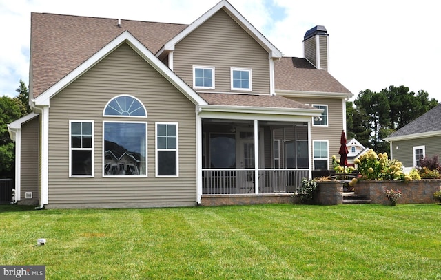 rear view of property featuring a lawn and a sunroom