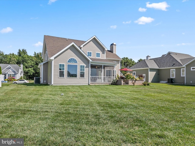 back of house featuring a yard, a sunroom, and central AC unit