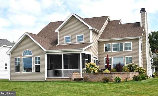 back of property with a lawn and a sunroom