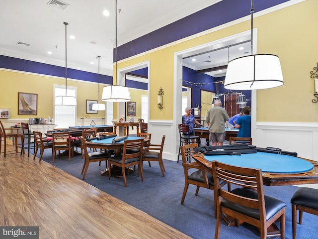 dining area with hardwood / wood-style floors and ornamental molding