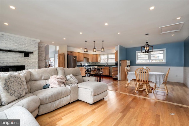 living room featuring a fireplace, sink, and light hardwood / wood-style floors