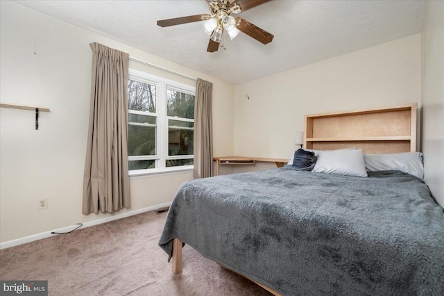 bedroom with ceiling fan, carpet flooring, and a textured ceiling