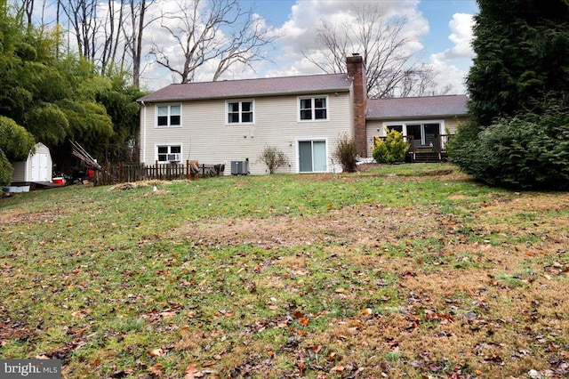 back of house with a shed, a lawn, and central air condition unit