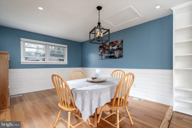 dining area with hardwood / wood-style floors and wood walls