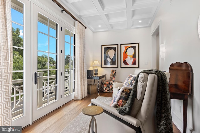 sitting room featuring coffered ceiling, plenty of natural light, light hardwood / wood-style flooring, and beamed ceiling