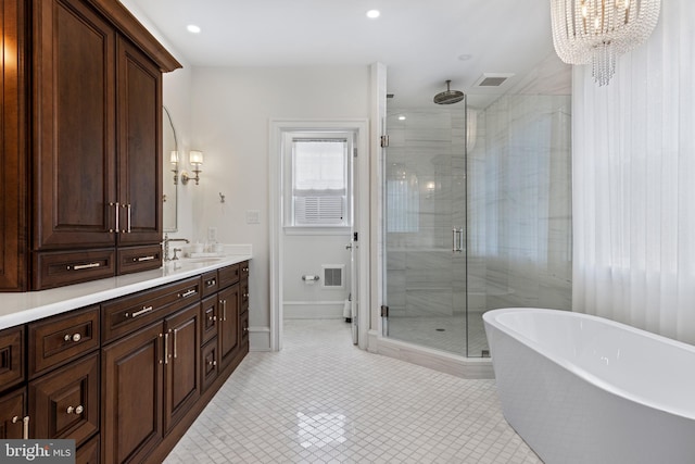 bathroom featuring vanity, tile patterned flooring, an inviting chandelier, and shower with separate bathtub