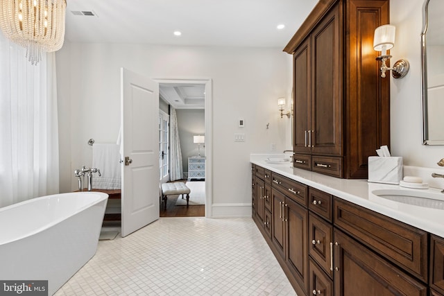 bathroom featuring vanity, a notable chandelier, and a washtub