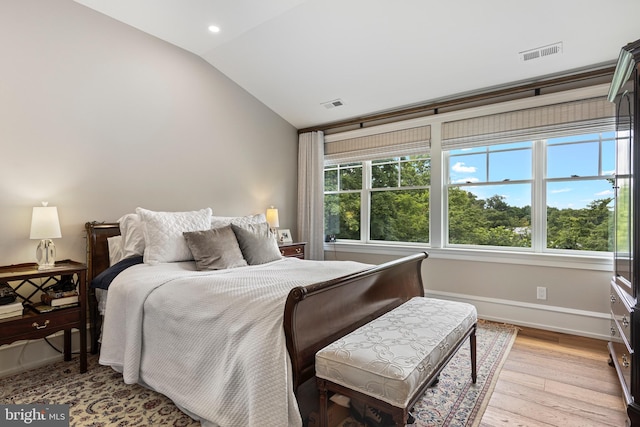 bedroom featuring lofted ceiling and light wood-type flooring