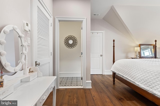 bedroom with vaulted ceiling and dark hardwood / wood-style flooring