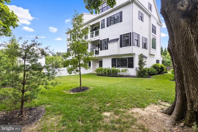 exterior space featuring a balcony and a lawn