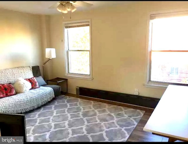 living area featuring wood-type flooring and ceiling fan