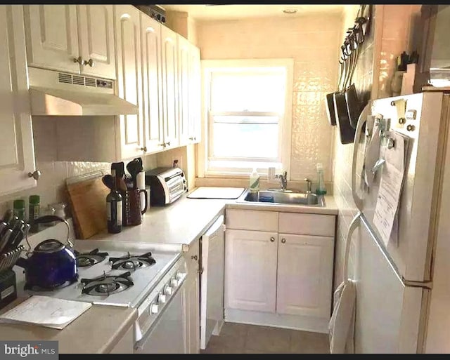 kitchen featuring dark tile patterned floors, sink, and white appliances