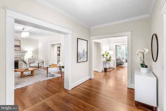 hall with wood-type flooring and crown molding