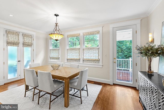 dining area with crown molding and light hardwood / wood-style floors