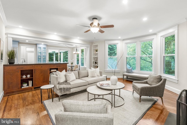 living area featuring recessed lighting, a ceiling fan, baseboards, ornamental molding, and light wood finished floors