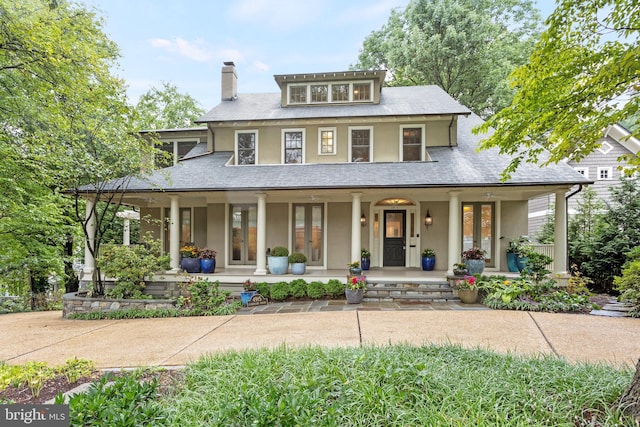 view of front facade with a chimney, a porch, french doors, and stucco siding