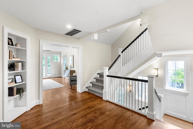 stairway with built in features and wood-type flooring