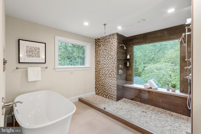 bathroom with recessed lighting, a tile shower, tile patterned flooring, a freestanding tub, and baseboards