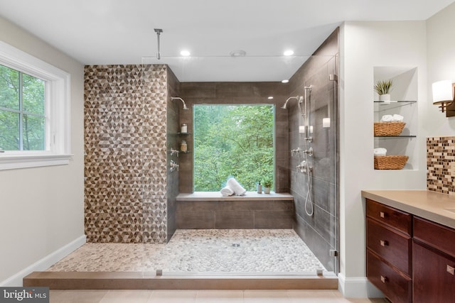 bathroom featuring a stall shower, vanity, and baseboards