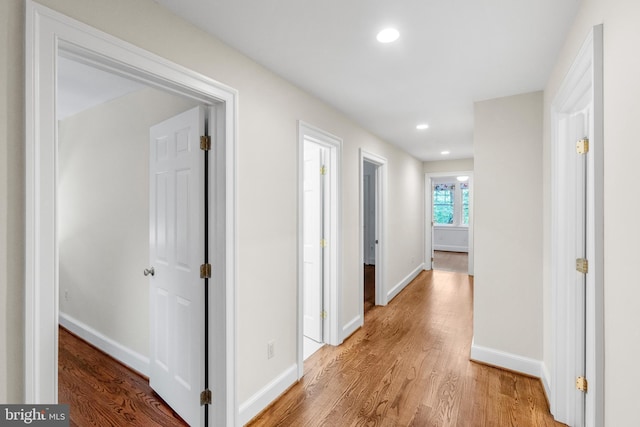 corridor with recessed lighting, light wood-style flooring, and baseboards