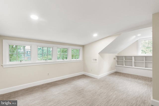 bonus room with a healthy amount of sunlight, carpet flooring, visible vents, and baseboards