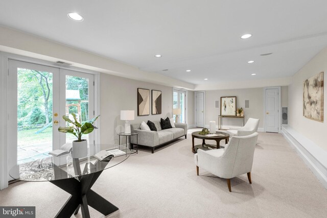 living area featuring baseboards, recessed lighting, visible vents, and light colored carpet