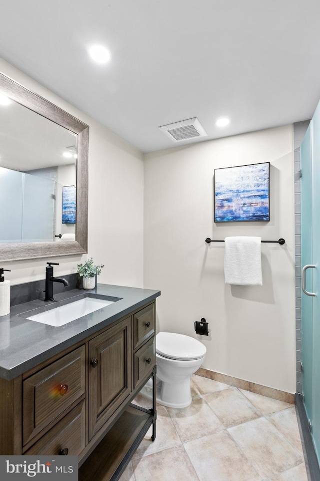 bathroom featuring vanity, toilet, tile patterned flooring, and a shower with door