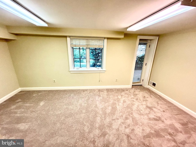 carpeted empty room featuring visible vents and baseboards