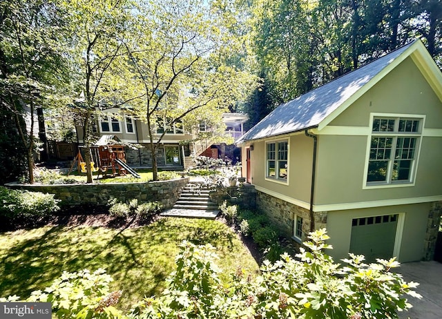 view of side of home featuring a garage and a playground