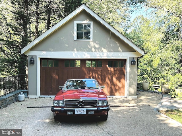 detached garage featuring fence