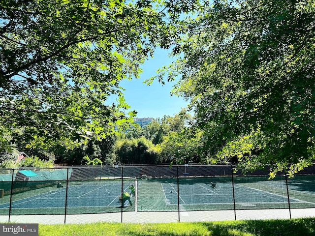 view of tennis court featuring fence