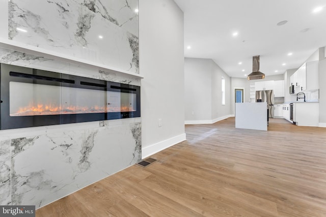 unfurnished living room with light hardwood / wood-style floors and a premium fireplace