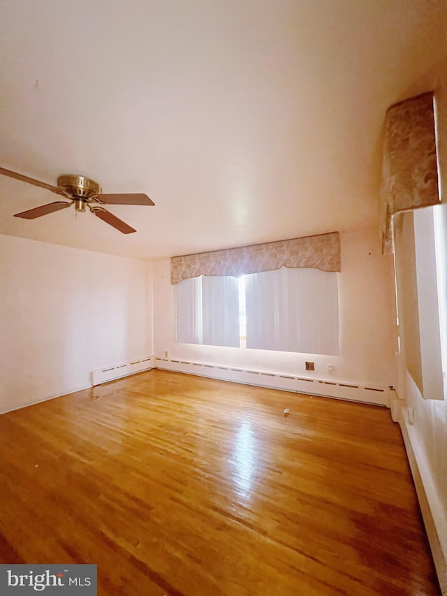 additional living space featuring ceiling fan, baseboard heating, and wood-type flooring