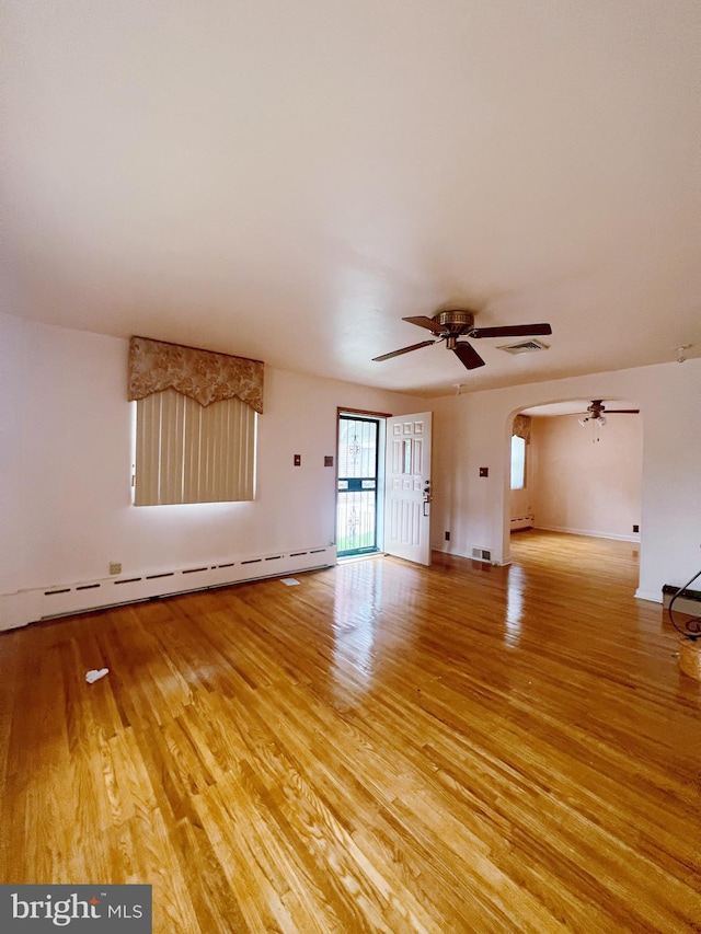 unfurnished living room with light wood-type flooring, a baseboard heating unit, and ceiling fan