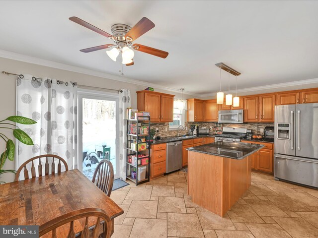 kitchen featuring a kitchen island, decorative light fixtures, stainless steel appliances, decorative backsplash, and ornamental molding