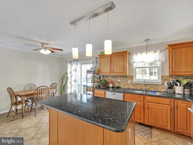 kitchen featuring decorative backsplash, sink, decorative light fixtures, and a center island