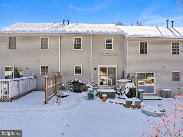 snow covered rear of property with central AC unit