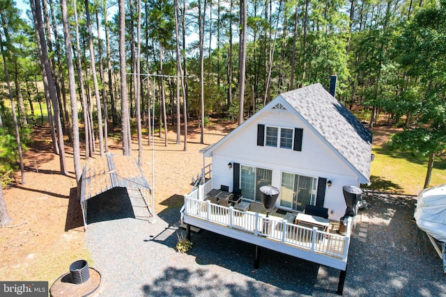 back of house featuring a deck and a shingled roof