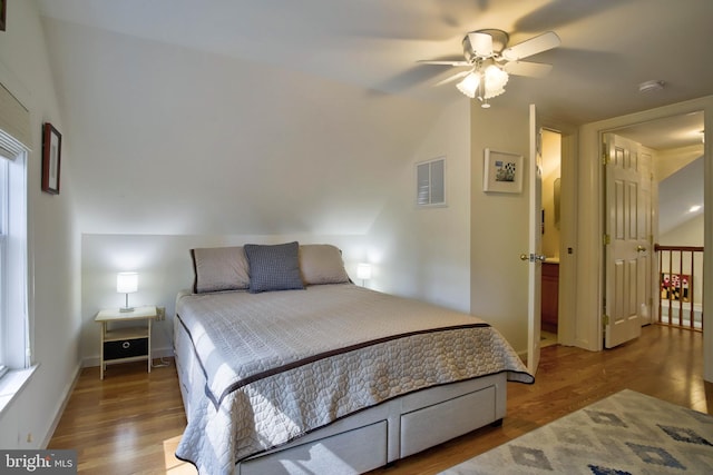 bedroom featuring ceiling fan, visible vents, baseboards, and wood finished floors